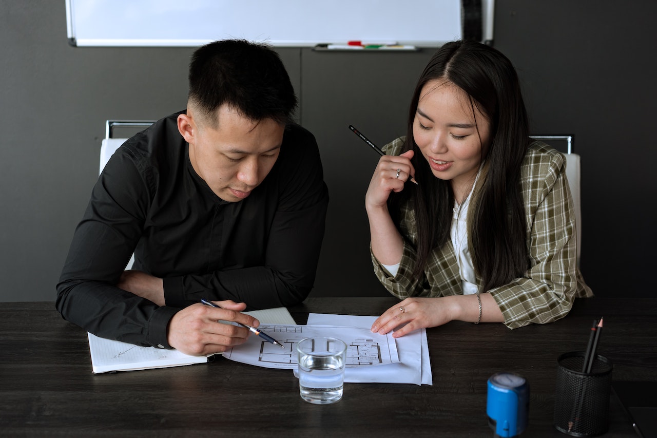 Picture of an Asian man and woman discussing work in the office
